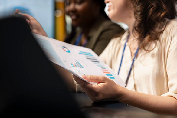 Person holds a report with charts during a business meeting.