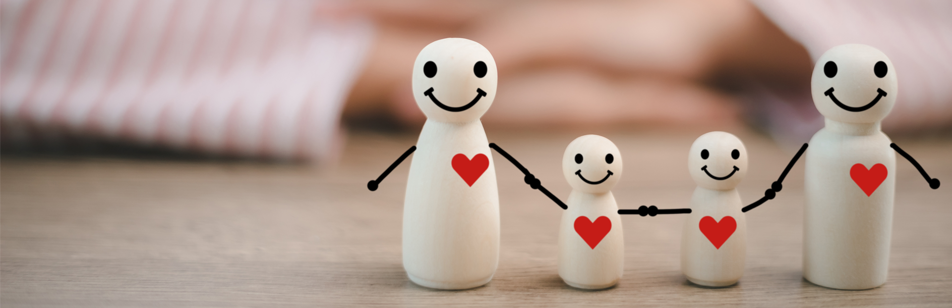small sculptures with hearts on the chest all holding hands to represent a family.
