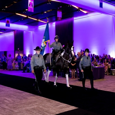 Horse with guards on each side at SLC 2026 closing.