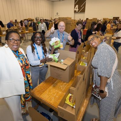 Happy group of people helping pack meals at the Campaign Hunger SLC 2026