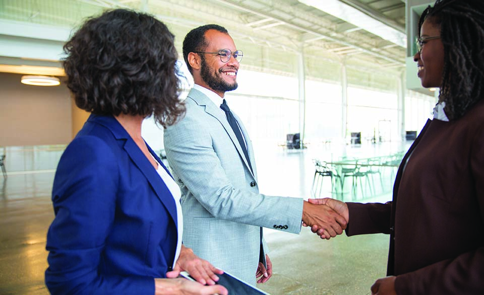 Business professionals meeting and shaking hands, representing public-private partnerships, collaboration, and oversight.