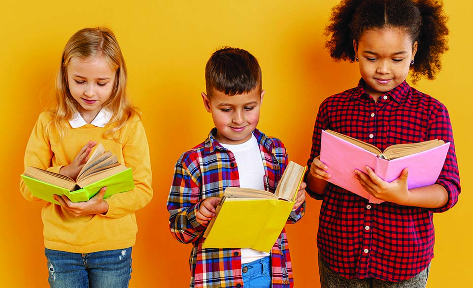 Elementary students reading books, illustrating literacy development, reading proficiency, and education policy initiatives.