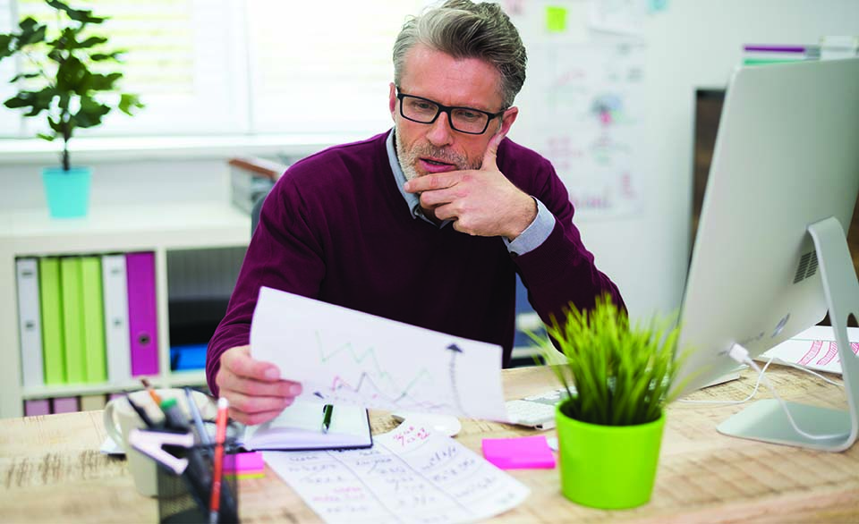 Professional reviewing financial charts and budget data at a desk, representing zero-based budgeting and fiscal planning.